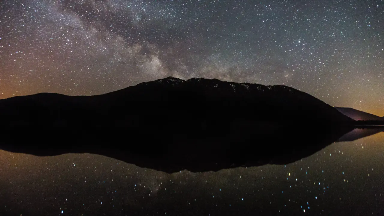 Stars reflecting across a lake in Glacier National Park