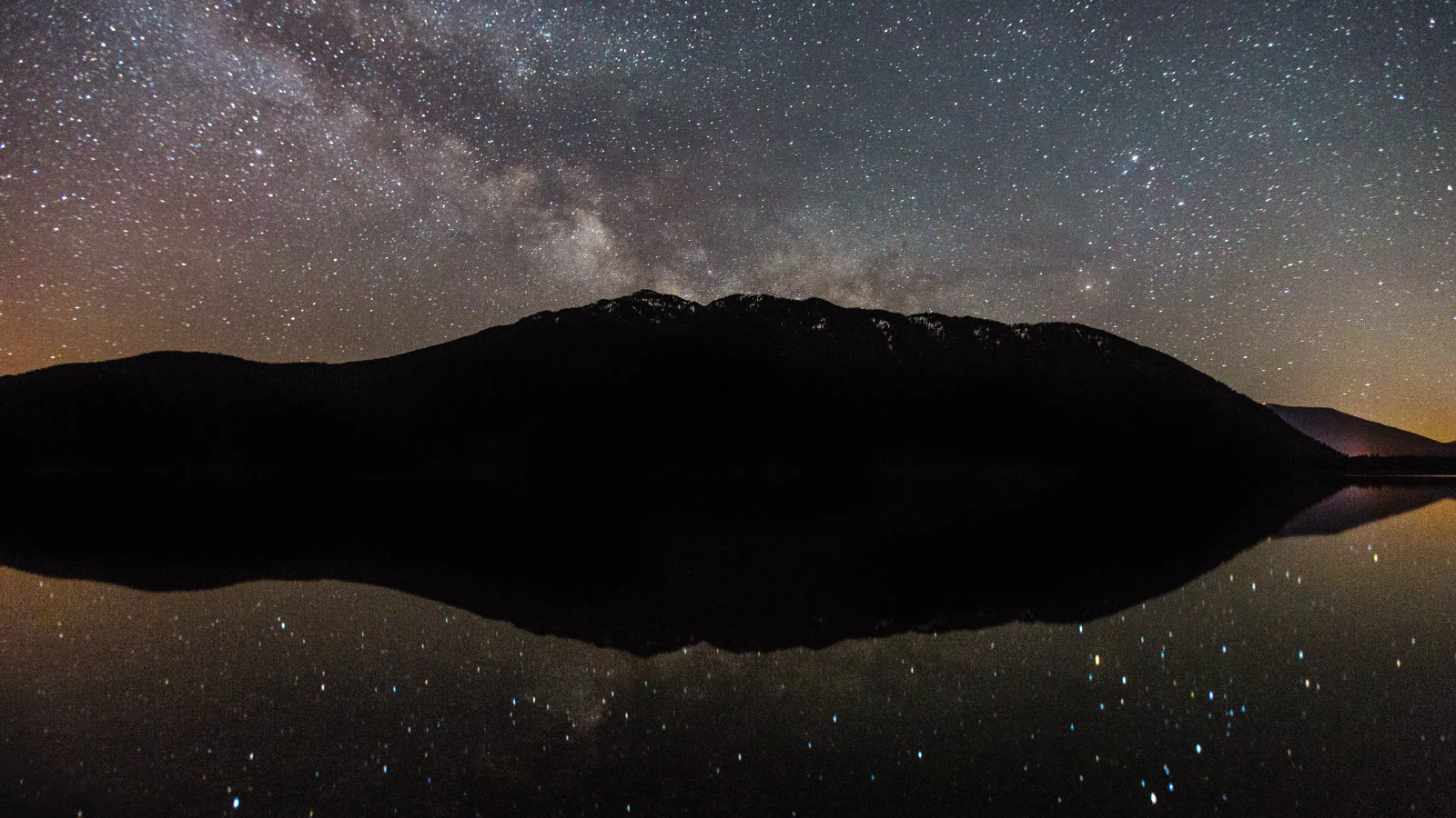Stars reflecting across a lake in Glacier National Park