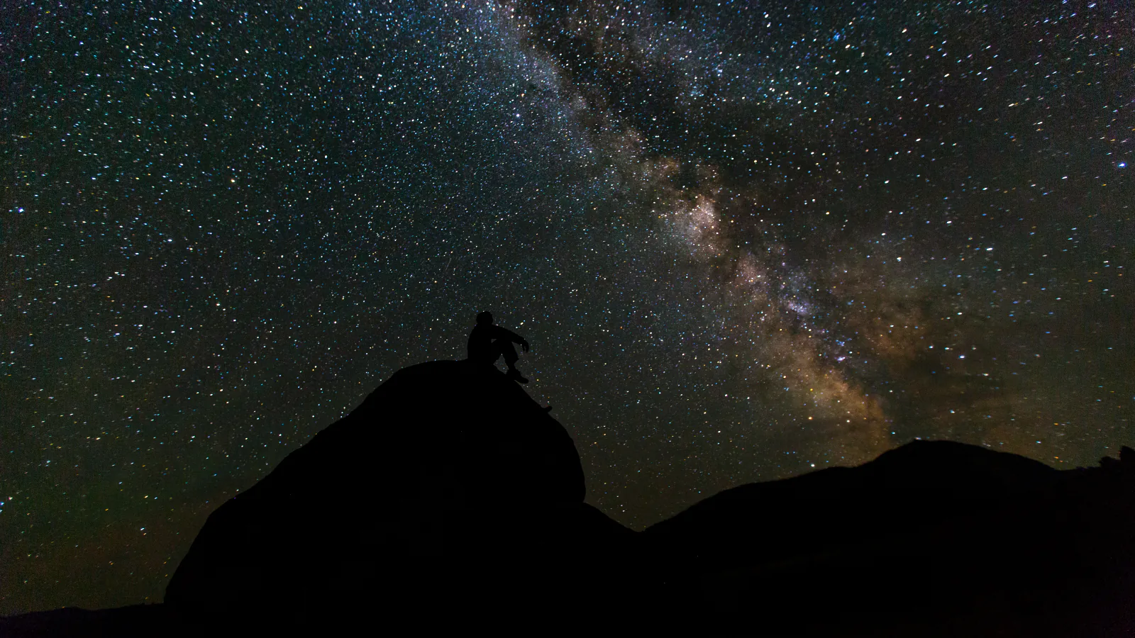 Silhouetted stargazer beneath the Milky Way in Yellowstone National Park