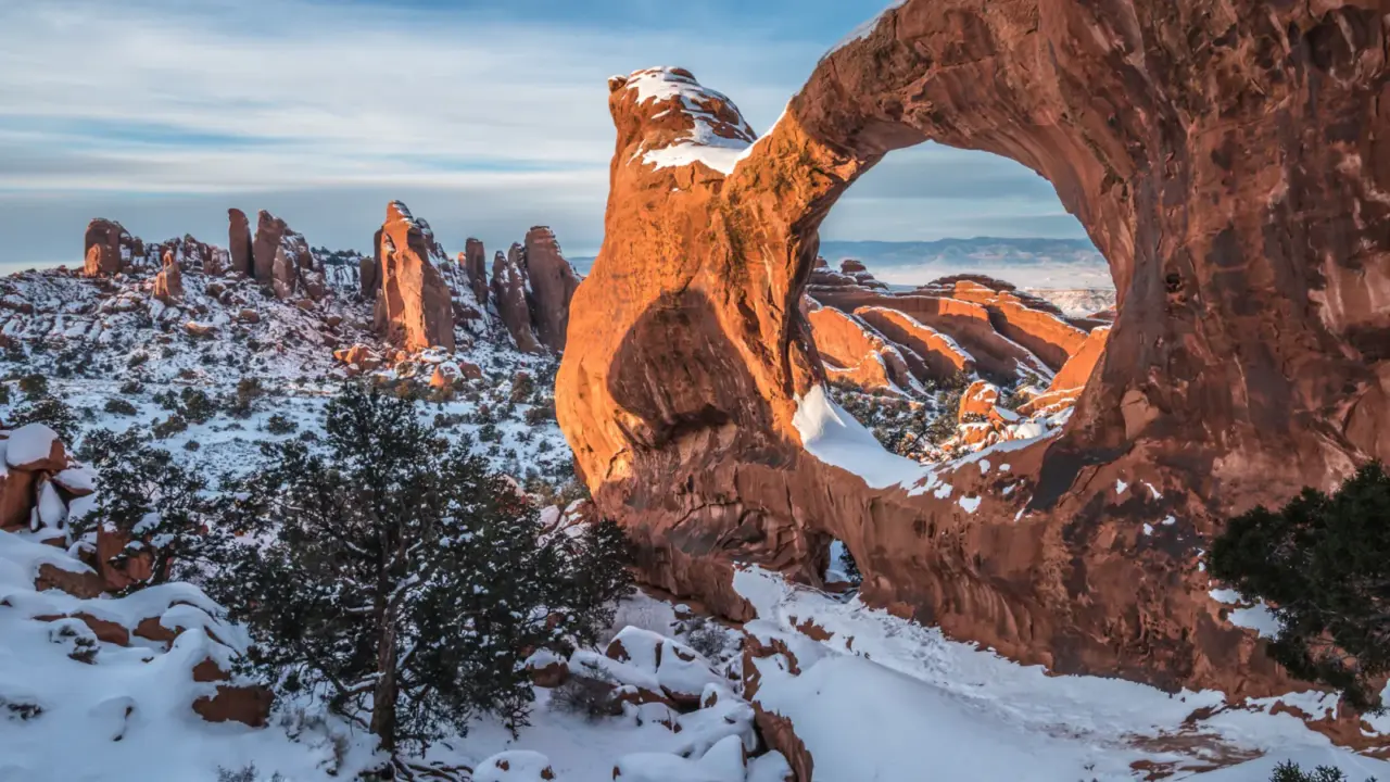 Snowy sunset at Double O Arch in Arches National Park