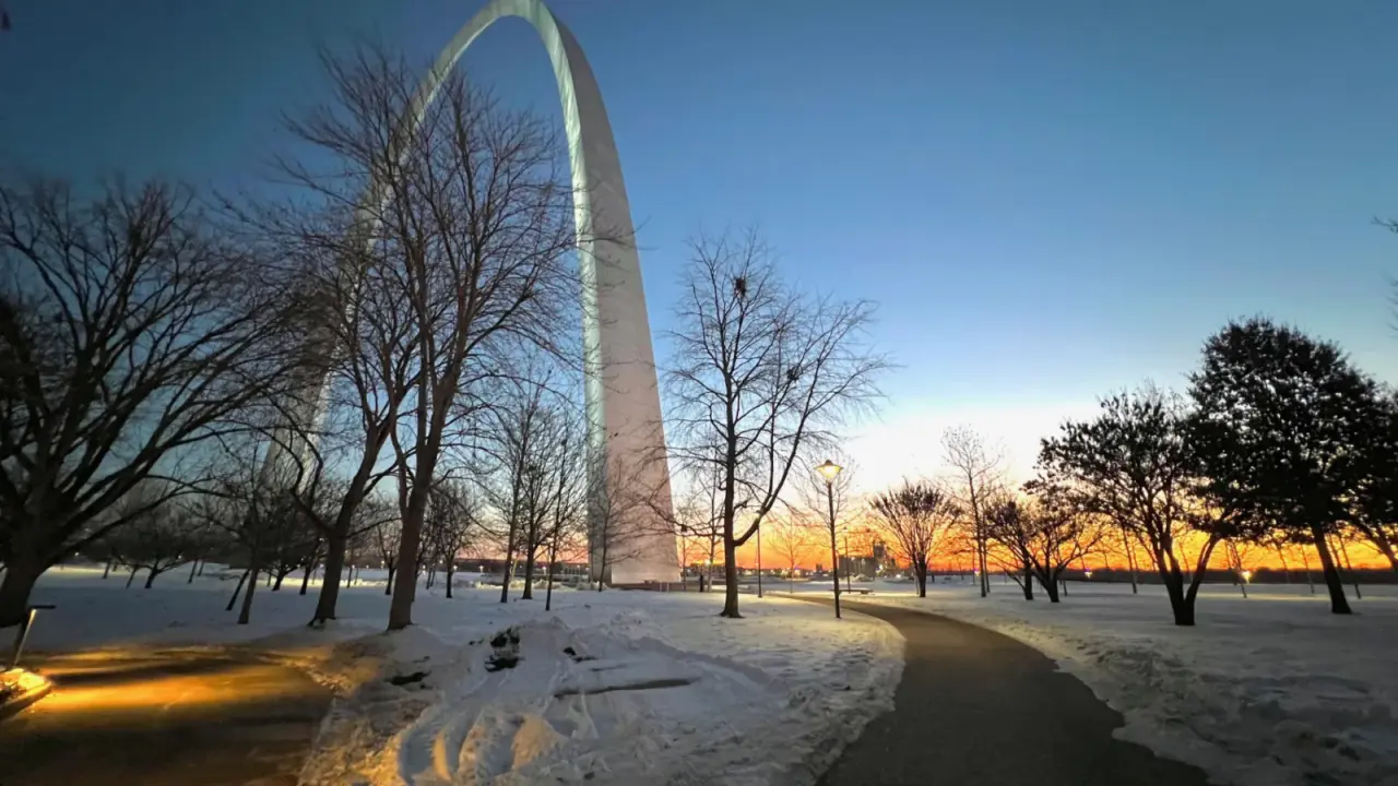 Winter sunrise above the snowy Gateway Arch grounds